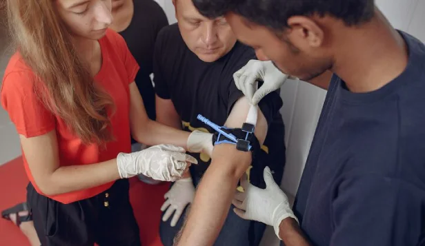 Students practising live blood collection in class